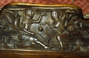 Wood carving of an early football game