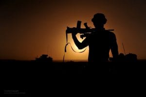 A soldier in silhouette, weapon against his shoulder