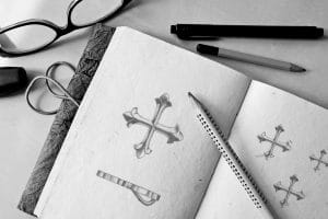 A sketchbook showing the design for a cross patonce charm.