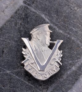 Silver badge depicting a profile of Winston Churchill and a Victory V in the foreground.