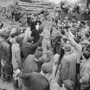 Winston Churchill is cheered by workers during a visit to bomb-damaged Plymouth on 2 May 1941. The Prime Minister was accompanied by Lady Nancy Astor, Lord Mayoress of Plymouth, behind Churchill.