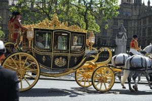 The Queen arrives at Westminster in a black and gold horse-drawn coach