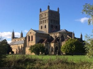 Tewkesbury Abbey in the sun, surrounded by trees