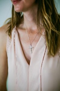 A sterling silver crucifix by Mallards, worn with a pale pink dress