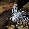 Silver bee pendant on a log